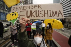 a young woman wearing a face mask holding a handmade sign